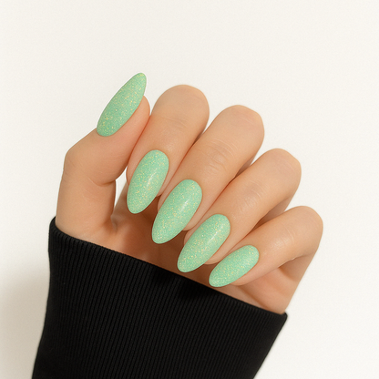 Mintgrön – Livlig mintgrön nyans med glittrande guld- och regnbågsskimmer / polygel på modellhand – Salongskvalitet UV/LED-polygel – Mandel-formade naglar