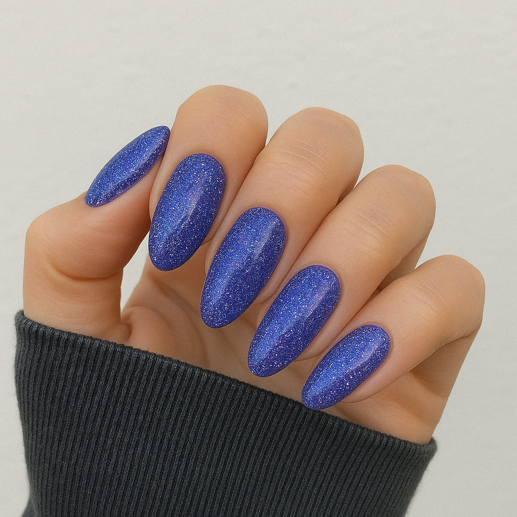 Starborn – Djupviolett med glitter och skimrande blå och rosa inslag / glittrigt gellack / gel polish på modellhand – Salongskvalitet UV/LED-nagellack – Mandel-formade naglar